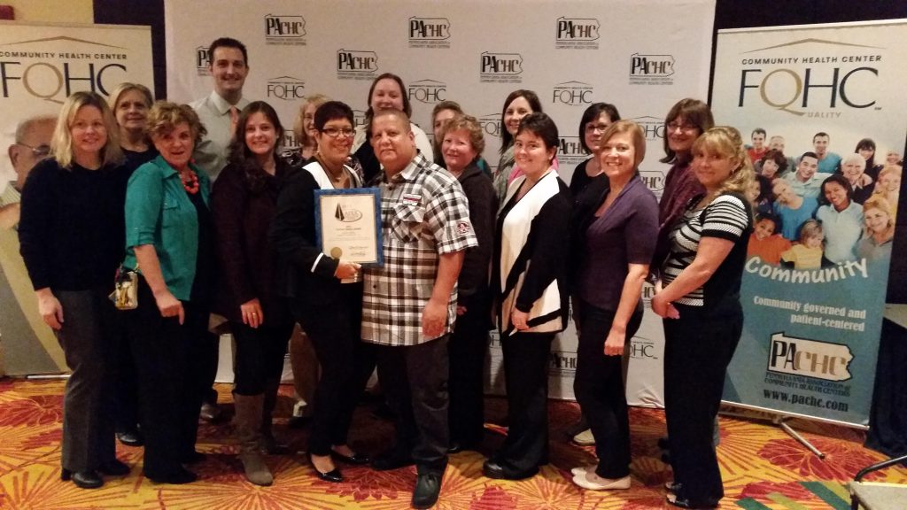 Nelly and her husband Angel are surrounded by Family First Health staff after she received the Patient Choice Award.