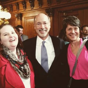Shannon McElroy and Karen McCraw get their photo taken with Gov. Tom Wolf after he signed the LGBT anti-discrimination order.