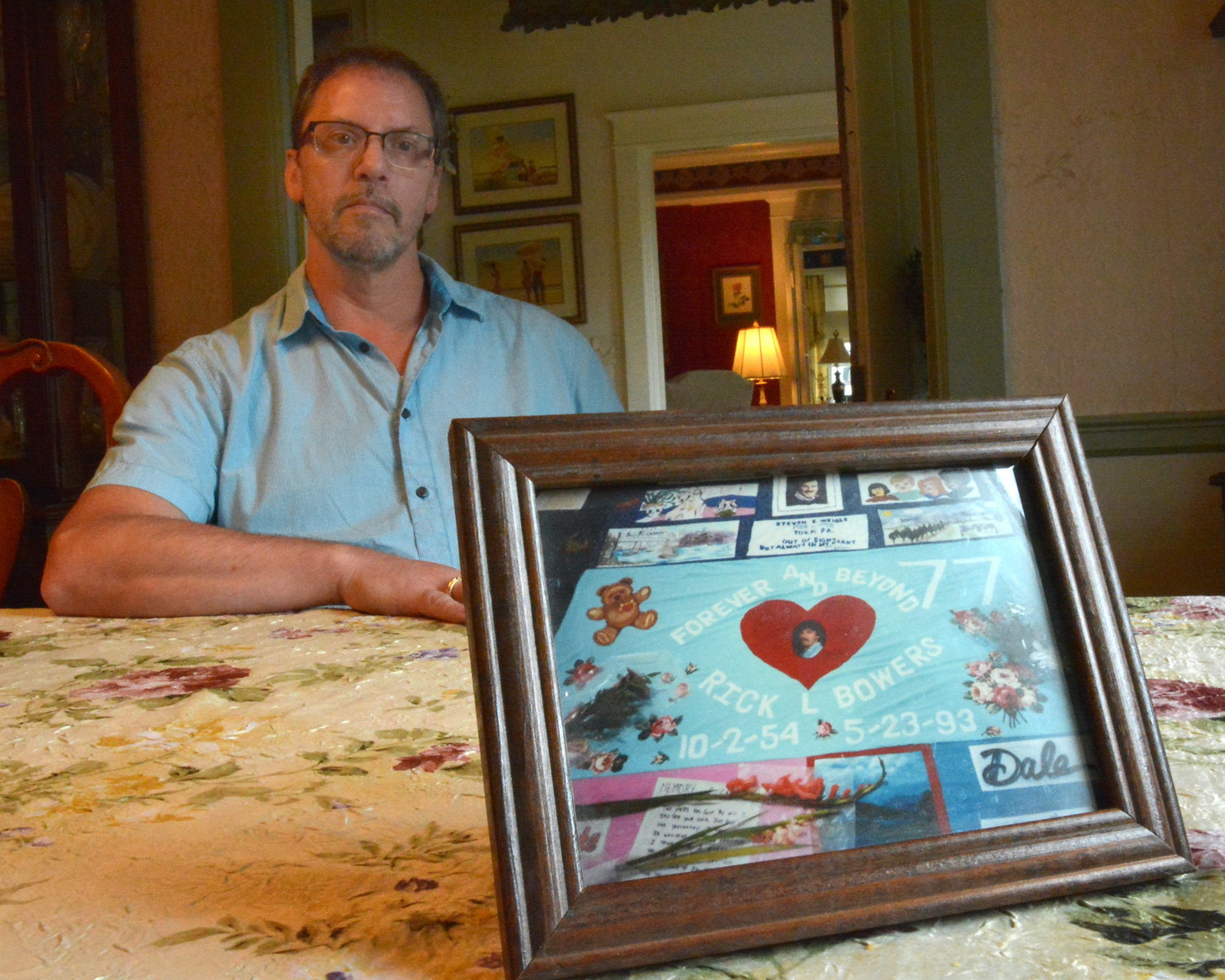 Scott Smith with picture of Aids quilt